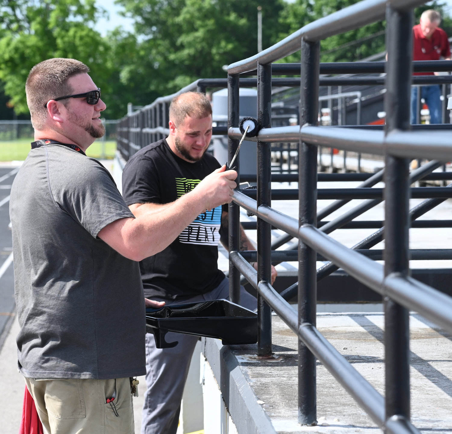 Andrew Castle and Joe Meola both from the Rome City School district paint the railings at RFA Stadium in preparation for next weeks' graduation ceremony.