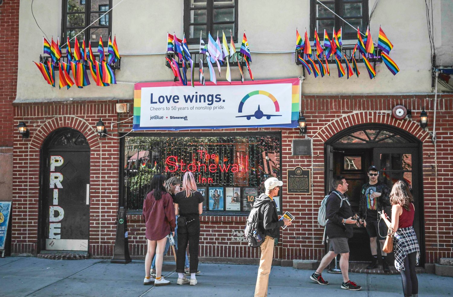 In this Monday, June 3, 2019, photo, Pride flags and colors display on the Stonewall Inn bar, marking the site of 1969 riots that followed a police raid of the bar’s gay patrons, in New York. A visitor center dedicated to telling the story of LGBTQ rights movement will open next door to the Stonewall Inn. Organizers say the groundbreaking for the Stonewall National Monument Visitor Center in New York City’s Greenwich Village neighborhood will take place Friday, June 24.
