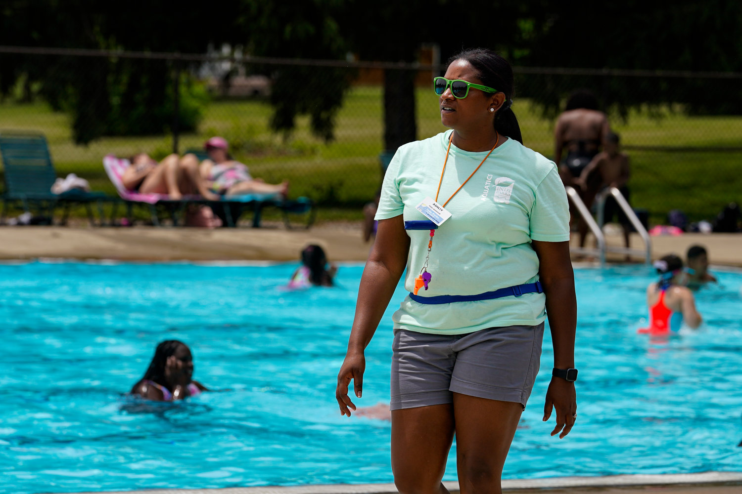 Pool manager Ashley Ford walks the pool deck during a at the Douglass Park pool in Indianapolis, Friday, June 17, 2022. Indianapolis typically fills 17 pools each year, but with a national lifeguard shortage exacerbated by the COVID-19 pandemic, just five are open this summer. The American Lifeguard Association estimates one-third of pools in the United States are impacted by the shortage. (AP Photo/Michael Conroy)