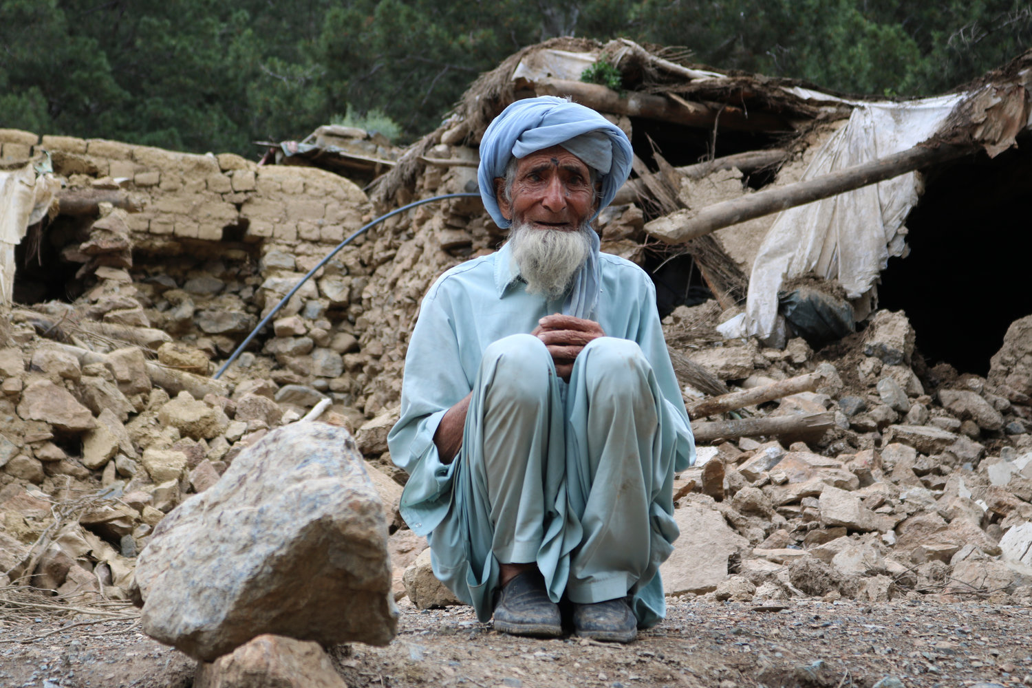 An Afghan man sits near his house that was destroyed in an earthquake in the Spera District of the southwestern part of Khost Province, Afghanistan, Wednesday. The powerful earthquake struck a rugged, mountainous region of eastern Afghanistan.