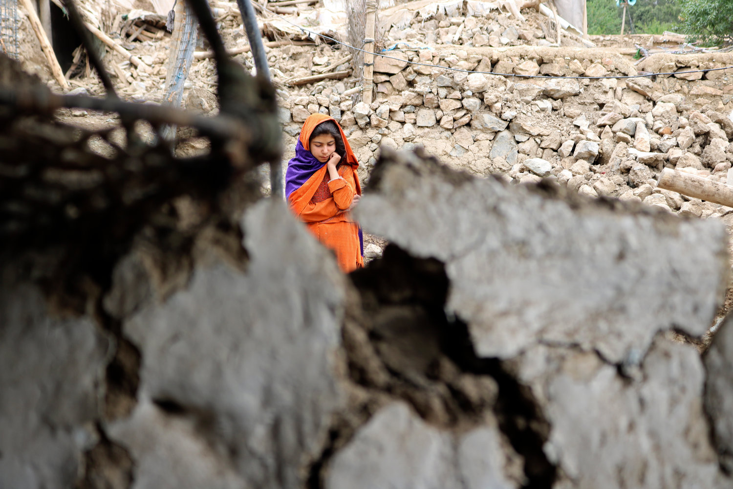 An Afghan girl stands near a house that was damaged by an earthquake in the Spera District of the southwestern part of Khost Province, Afghanistan, Wednesday, June 22, 2022. A powerful earthquake struck a rugged, mountainous region of eastern Afghanistan early Wednesday, killing at least 1,000 people and injuring 1,500 more in one of the country's deadliest quakes in decades, the state-run news agency reported. (AP Photo)