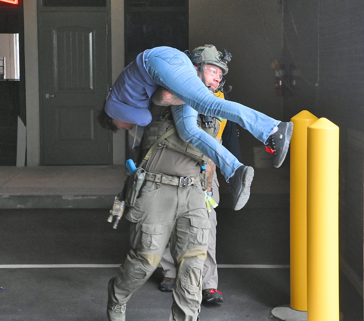 A role-player is carried to safety by a member of the Erie County Sheriff's SWAT team during a training scenario at the New York State Preparedness Training Center in Whitestown.
