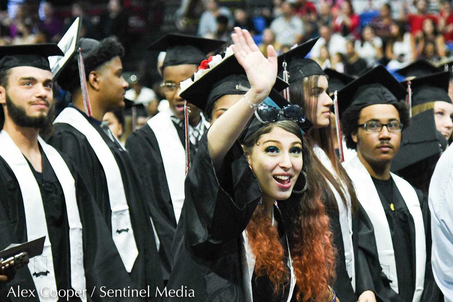 Graduate Yanalise Correa Dejesus waves to the crowd during the annual commencement ceremony for Thomas R. Proctor High School on Friday at the Adirondack Bank Center at the Utica Memorial Auditorium.