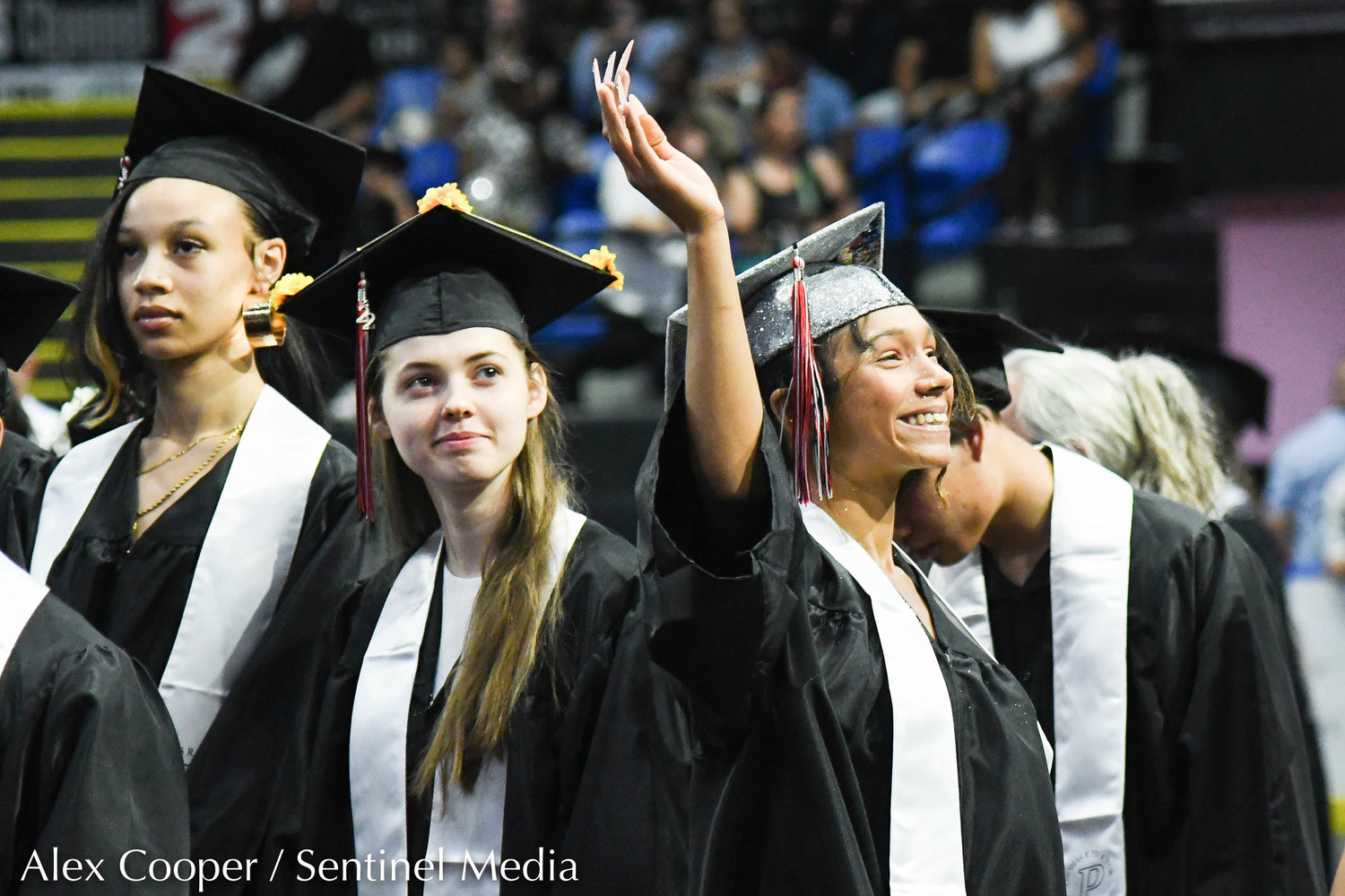 Graduate Desirae Stewart smiles and waves to family members during the annual commencement ceremony for Thomas R. Proctor High School on Friday at the Adirondack Bank Center at the Utica Memorial Auditorium.