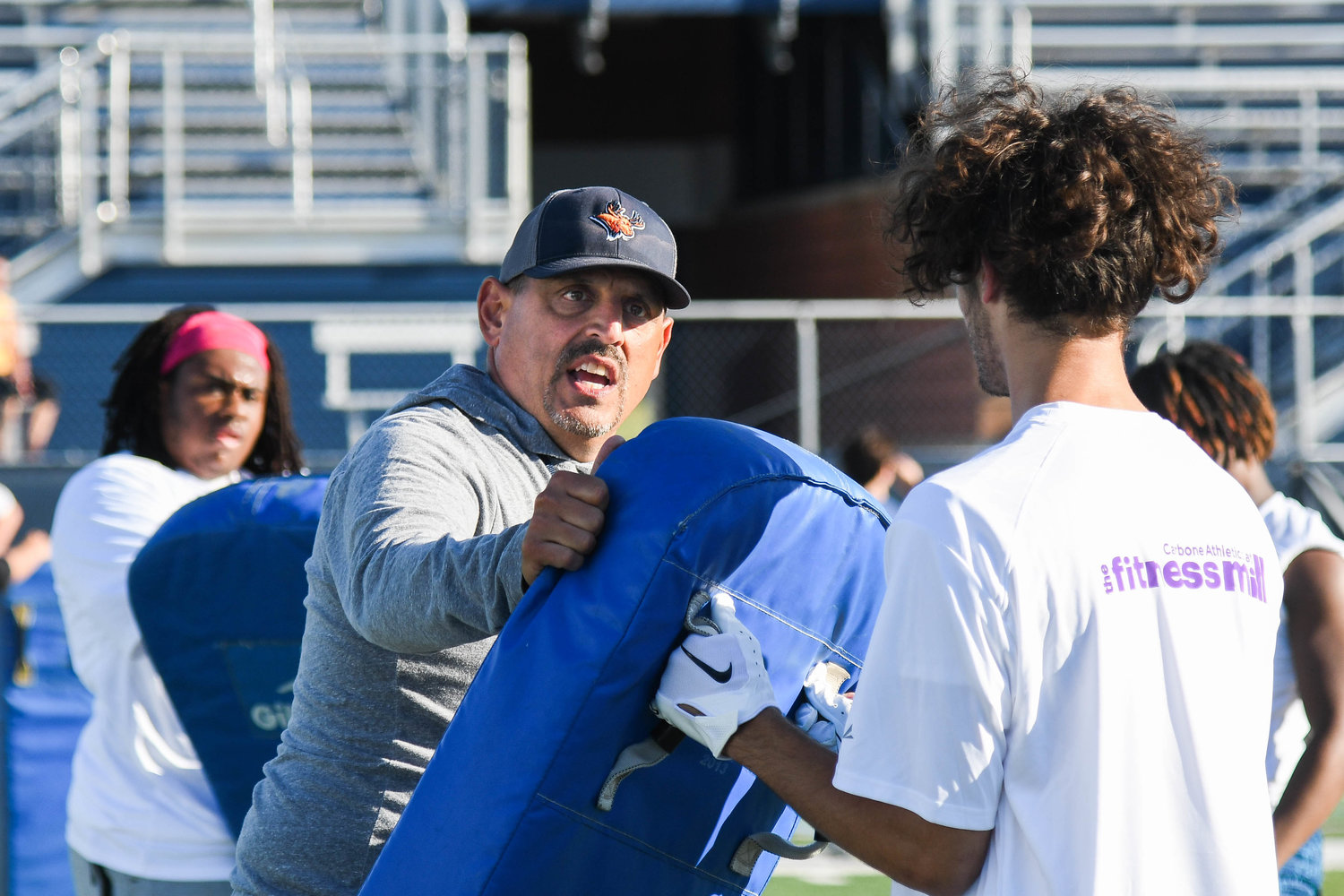 CAMP DRILLS — Utica University football head coach Blaise Faggiano runs drills with players during the fifth annual “A Call to Men” football camp on Tuesday night at Charles A. Gaetano Stadium in Utica. The two-day football camp was sponsored by Kristin’s Fund, a non-profit organization dedicated to creating safer communities through domestic violence prevention, Faggiano and the Pioneers staff.