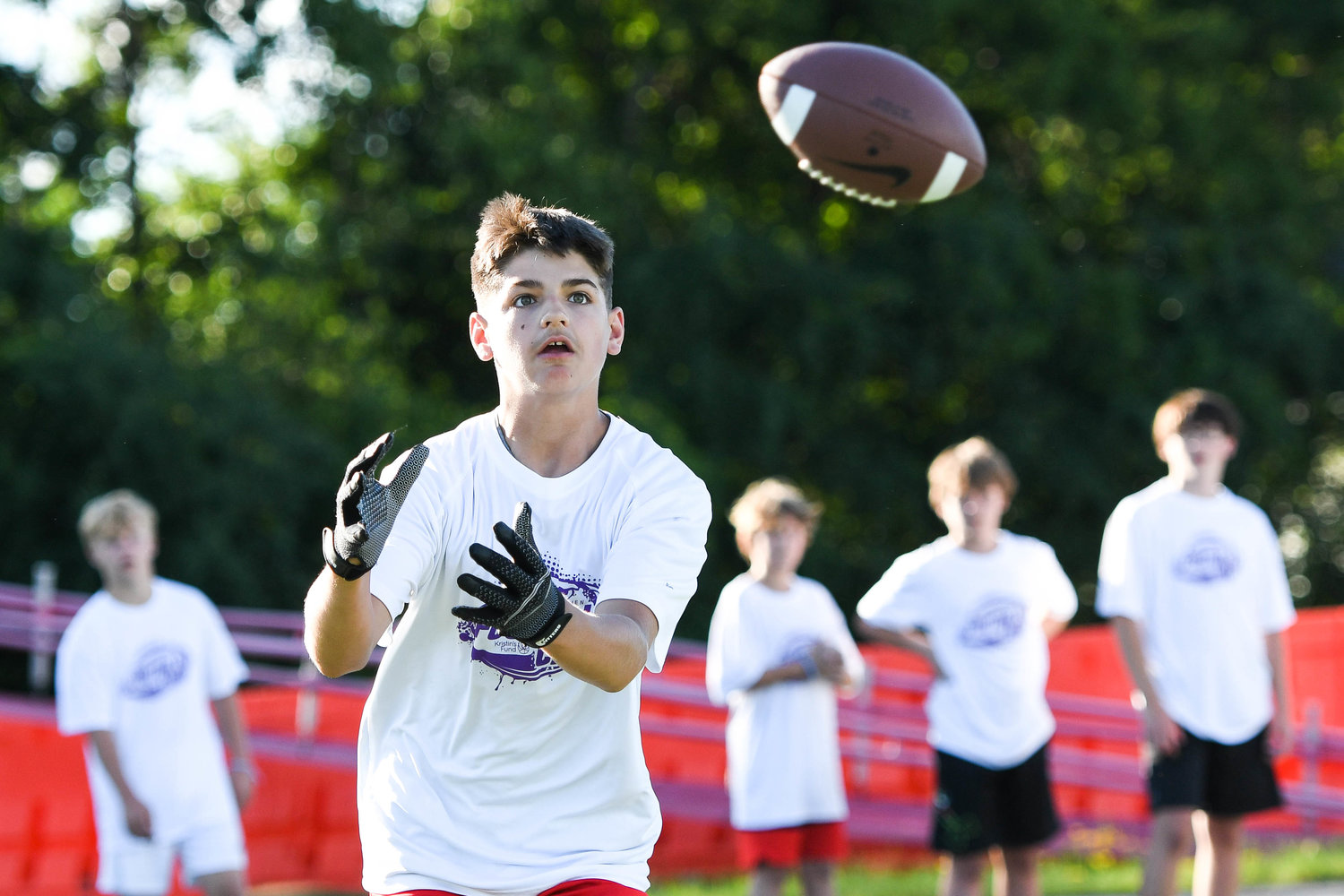 EYES ON THE BALL — Taegen Johnson, of Dolgeville, prepares to catch a ball during drills at the fifth annual “A Call to Men” football camp on Tuesday night at Charles A. Gaetano Stadium at Utica University. Celebrity guests coaches included Minnesota Vikings tight ends coach Brian Angelichio, a 1991 Ilion High School graduate, and former Syracuse football star Don McPherson.