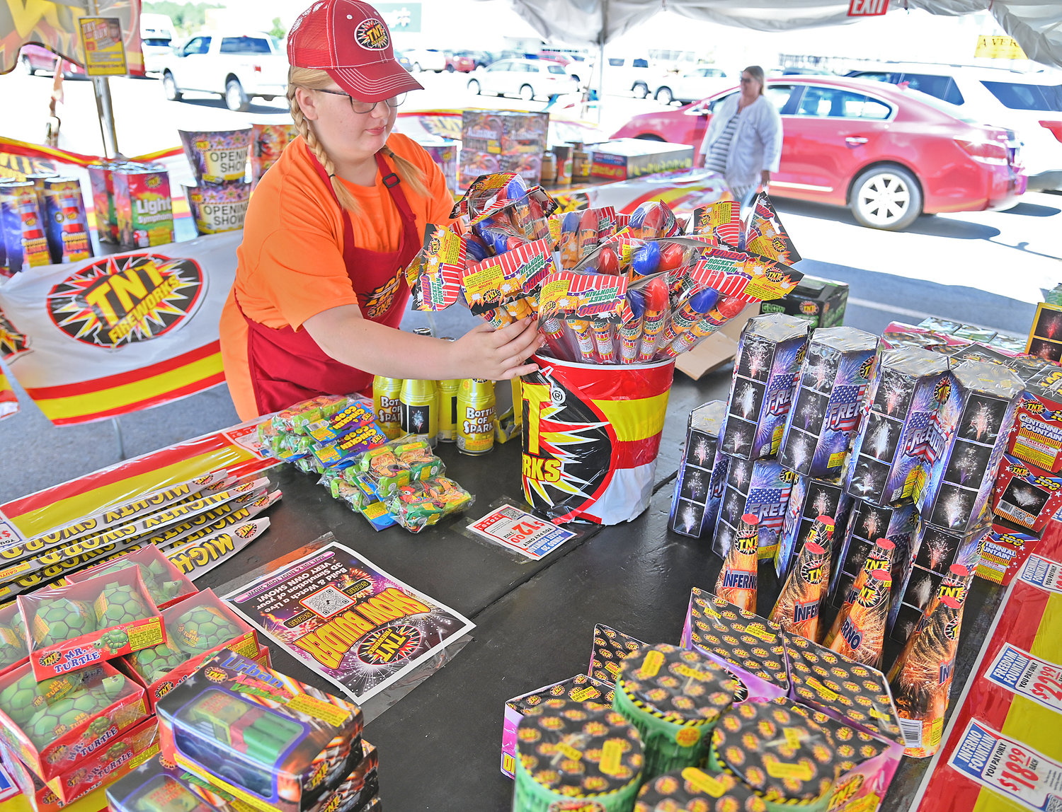 Brooke Wright, age 13, daughter of Jason and Denise Wright, organizes the jumbo rocket fountain fireworks at the TNT Fireworks tent at Walmart in Rome this week.