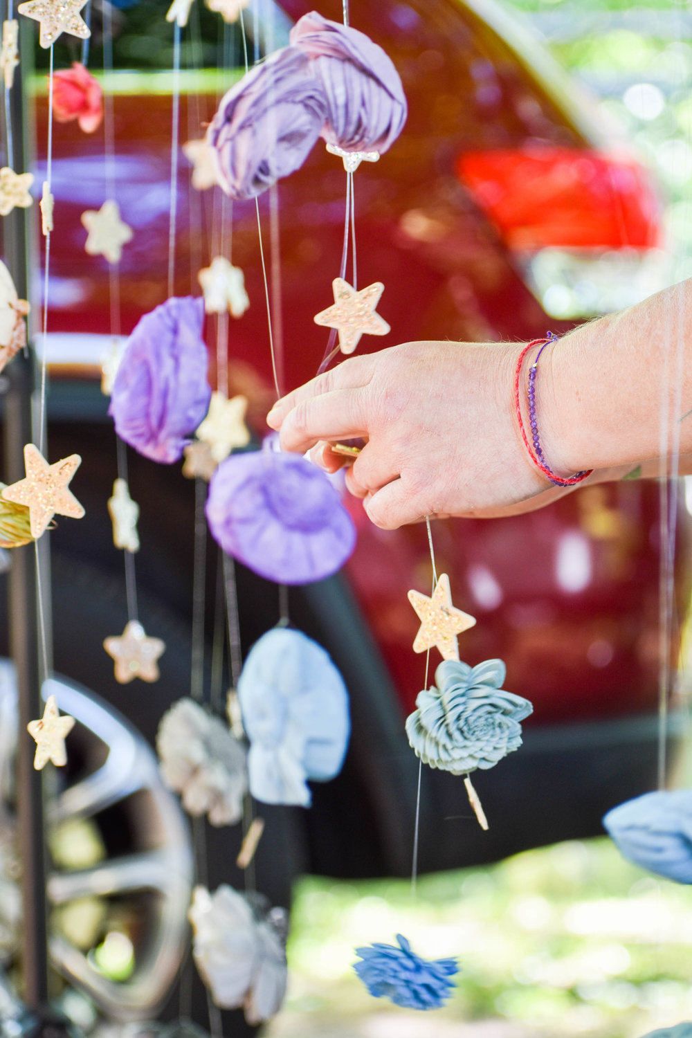 Brandi Gall of Wooden Moon Studio arranges the decorative pieces hanging from one of her ceiling mobiles, which make popular gifts for baby or bridal showers, she said.