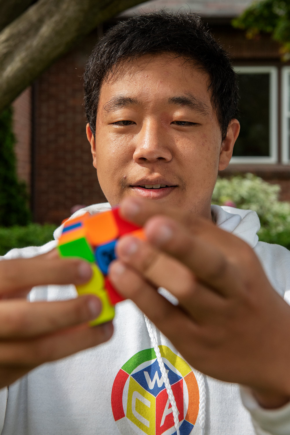 ERICA MILLER/THE DAILY GAZETTE   Benjamin Graber, 16, outside his home with his rubix cubes in Niskayuna on Wednesday, June 29, 2022. Graber is set to compete this weekend in the World Cube Association NYS Championship in Albany.