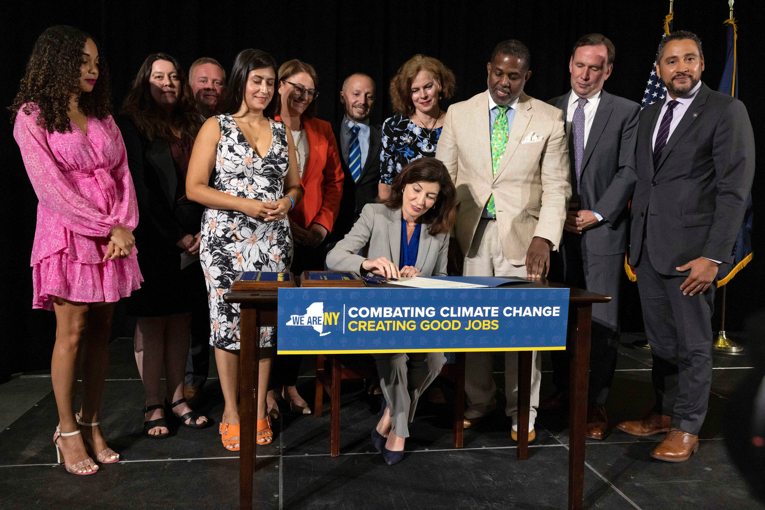 New York Gov. Kathy Hochul signs a legislative package to reduce greenhouse gas emissions and create green jobs during a press conference, Tuesday, July 5, 2022, at the Brooklyn Navy Yard in the Brooklyn borough of New York. (AP Photo/Yuki Iwamura)