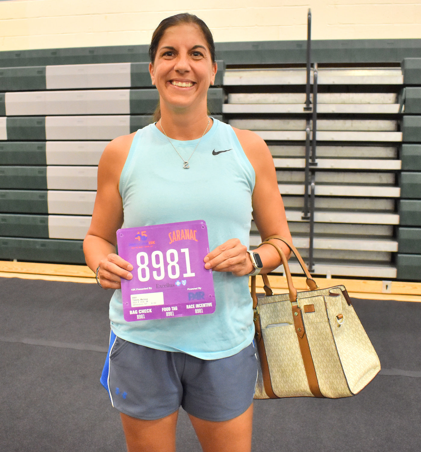 Melissa Tibbits, of Whitesboro, picks up her charity bib for the 15K race. This year, Tibbits is running in support of pediatric cancer charity, “On My Team 16.”