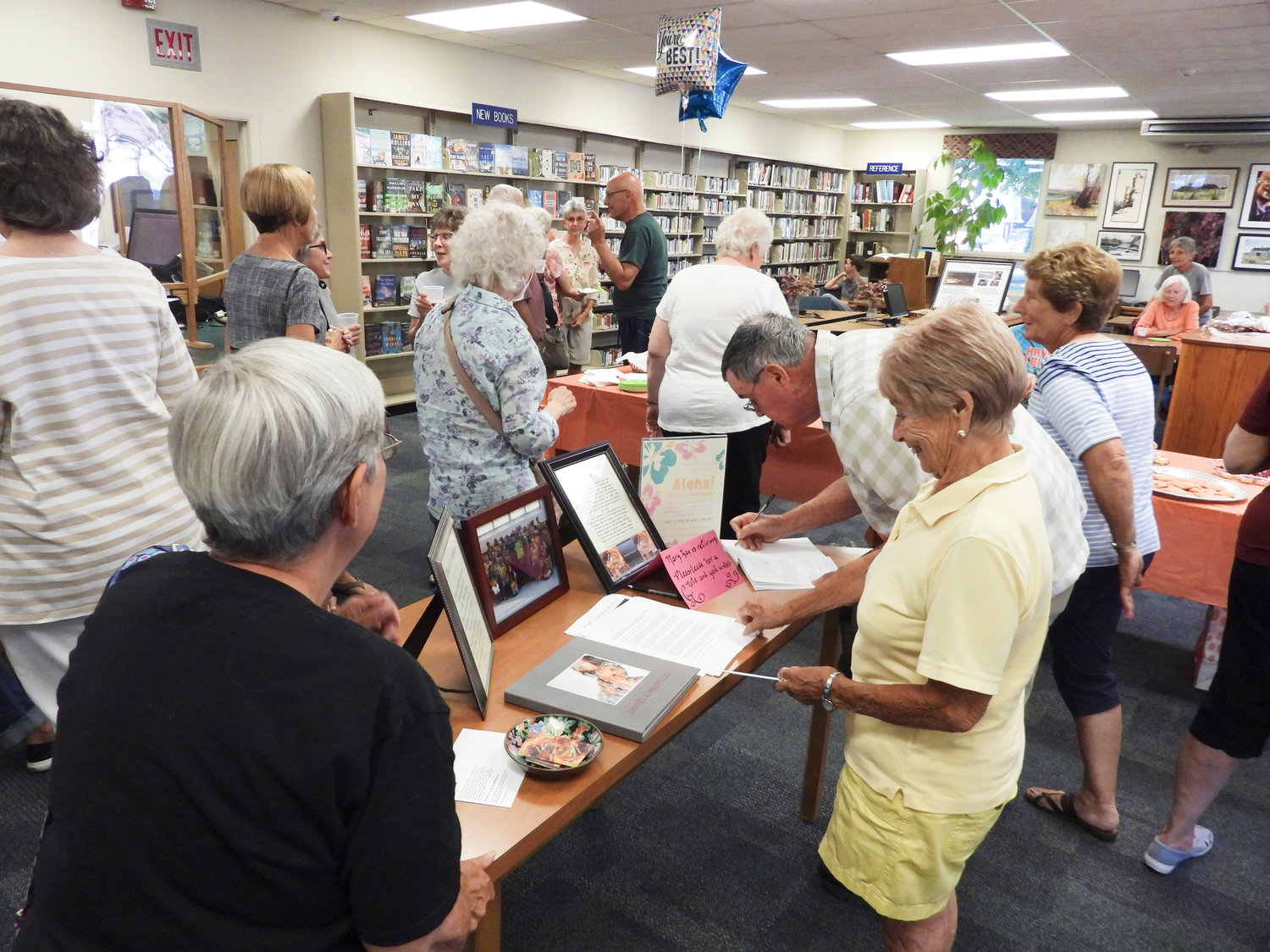 Local residents and patrons attend the Aloha Celebration and Reception at the Sherrill-Kenwood Library, wishing Mary Kay Junglen a happy retirement and welcoming new Library Manager Bill Loveland