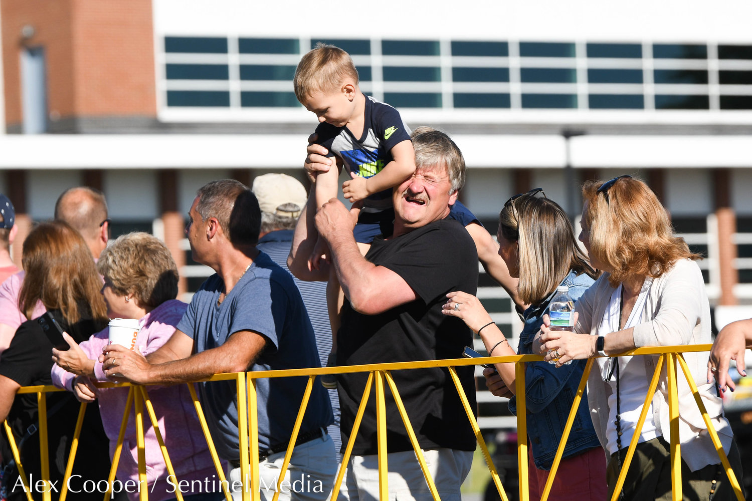 A young boy tries to get a better view at the race during the Utica National Kids Run at Mohawk Valley Community College in Utica on Saturday.