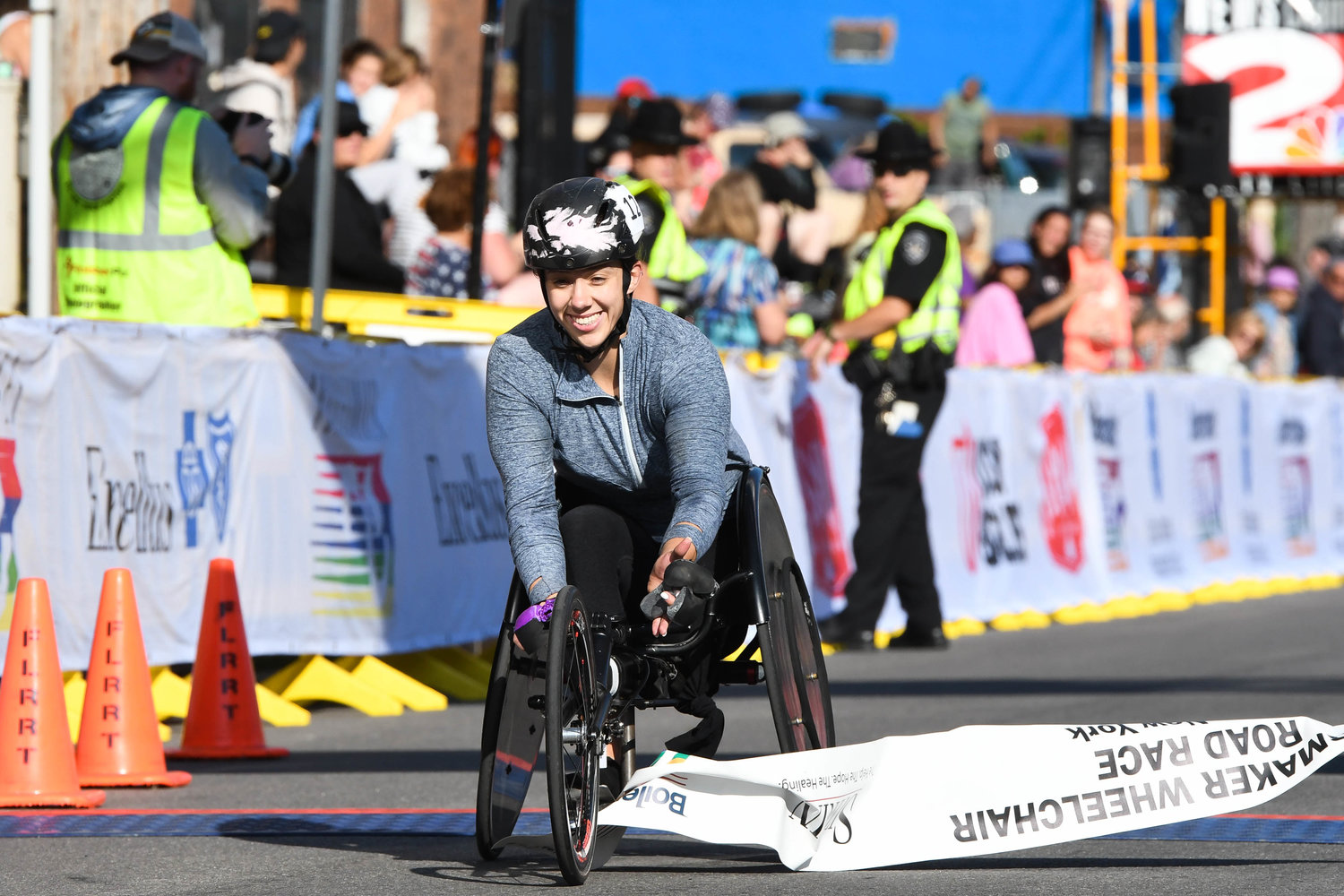 Jenna Fesemyer crosses the finish line with the best time among women competitors in the wheelchair 15K at the 45th Boilermaker Road Race on Sunday in Utica. It was her second time winning the women's race, three years after her first.