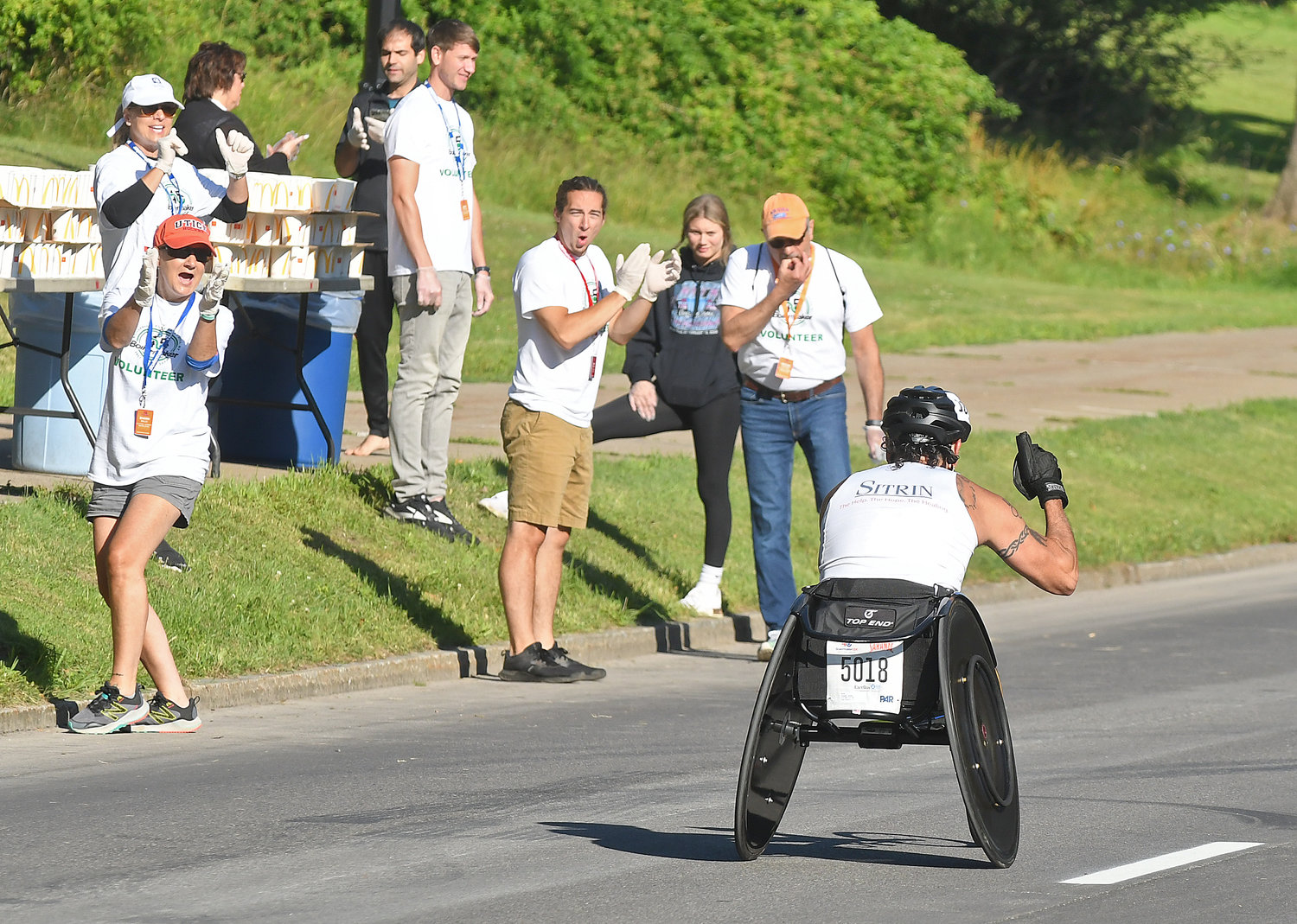 Wheelchair racer James Joseph of New Hartford gives a thumbs up to spectators cheering him on as he rockets down Memorial Parkway after coming down Master Garden Road in the 45th Boilermaker Road Race Sunday. Joseph was 25th in the race.