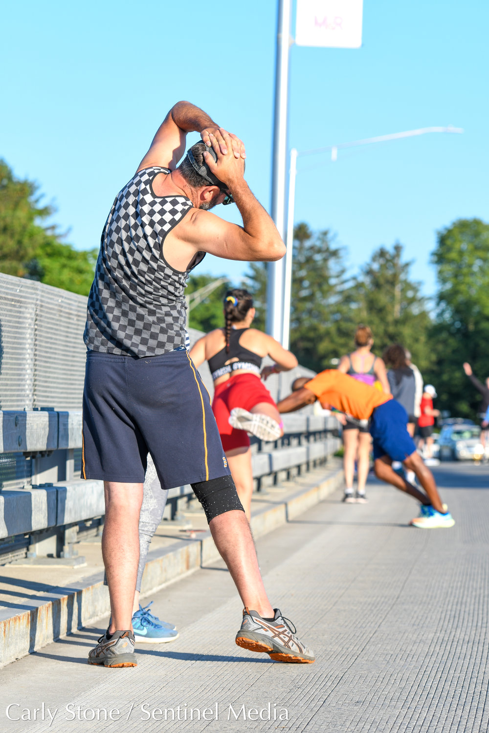 Jon Taylor, from Poland, New York, stretches on Burrstone Road bridge before running in the 2022 Boilermaker 5K in Utica.