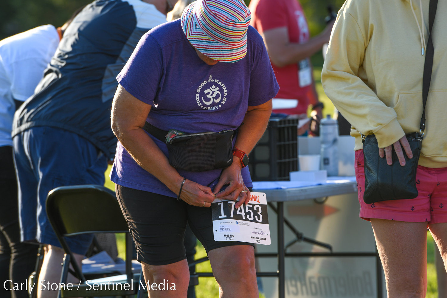 Annette Lewis, from Malta, fastens her bib number on her clothing as she gears up for the 2022 Boilermaker 5K.