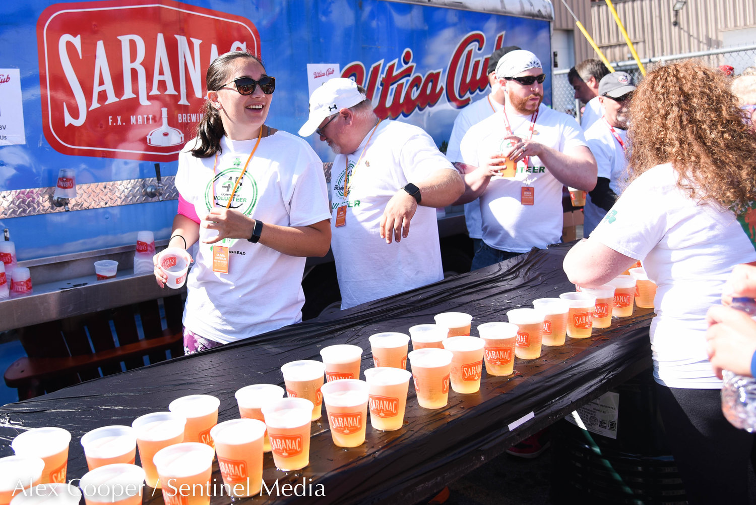 Volunteers serve cold brews at the Saranac Post Race Party following the 45th Boilermaker Road Race in Utica.