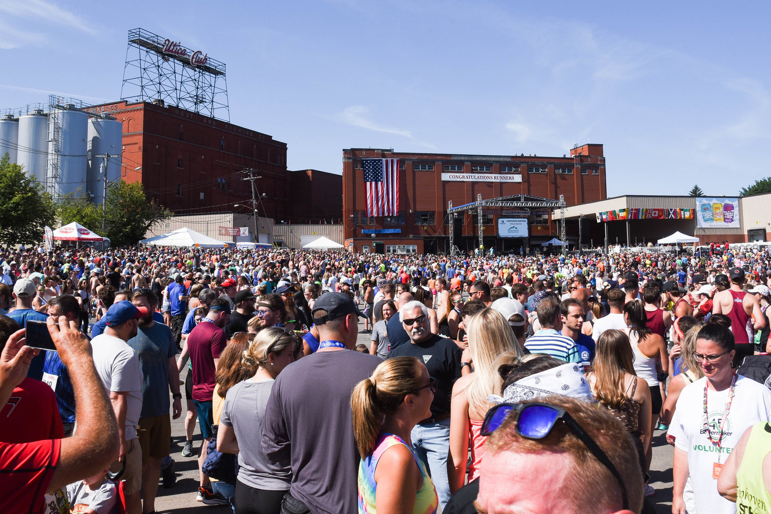 Runners and spectators enjoy the Saranac Post Race Party in the brewery courtyard following the 45th Boilermaker Road Race on Sunday.