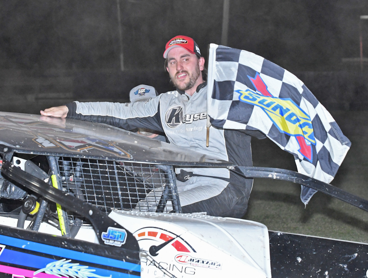 CAPTURING THE CHECKERED FLAG — Justin Wright, of York, NY, won his first modified feature race of the season at Utica-Rome Speedway last Friday night. He won the first of the two 20-lap twin modified features.