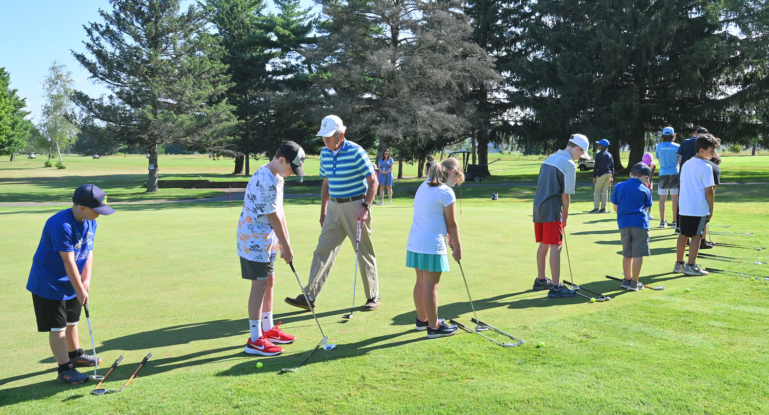 Golf instructor Paul Panek teaches a group of children how to chip during their first lesson on the Mohawk Glen practice green Wednesday. This is Panek's 24th year of teaching the summer program.