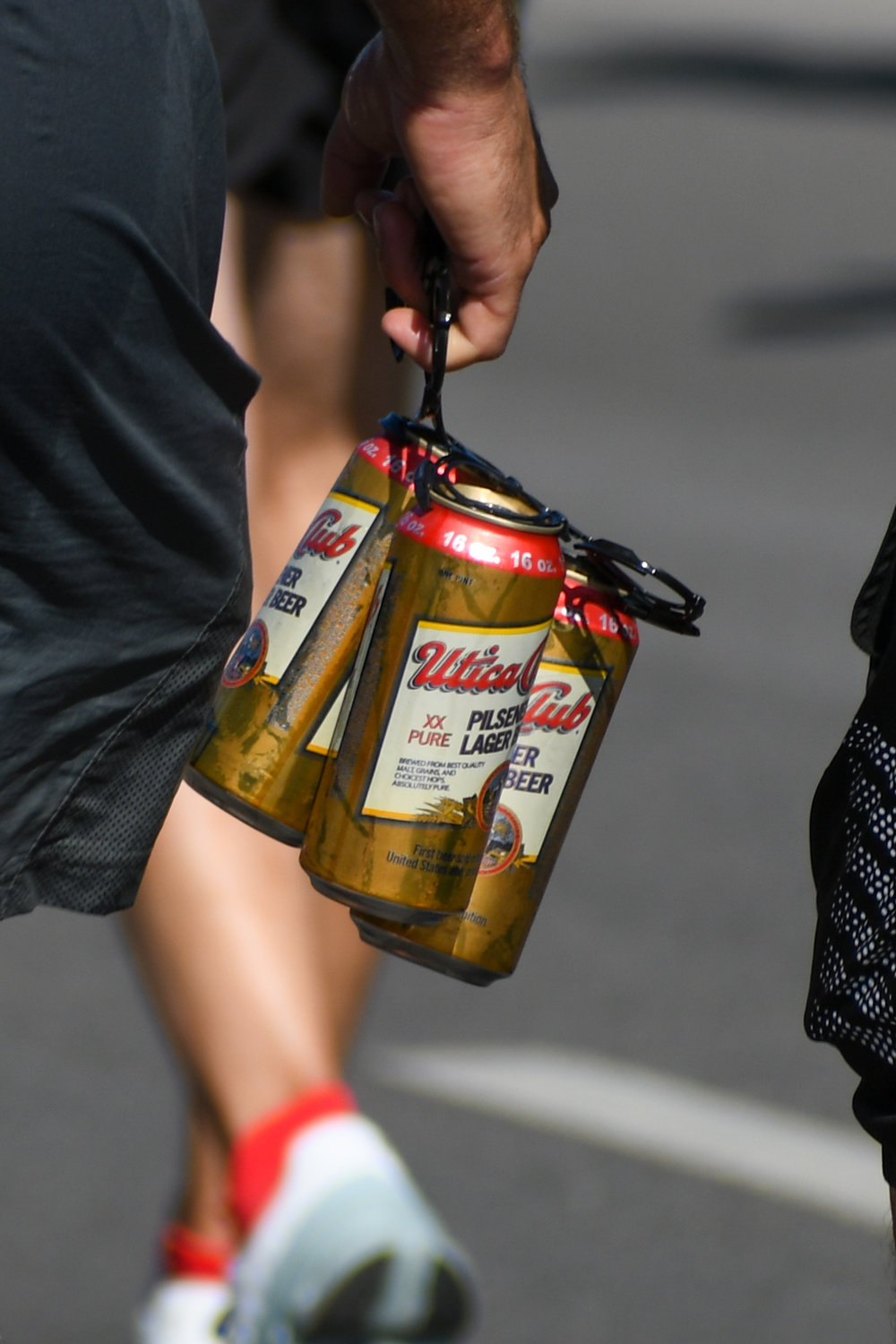 One runner sought to refuel with Utica Club, carrying a six-pack and taking a drink along the 15K Boilermaker course.