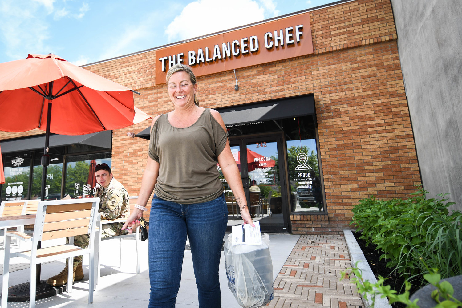 Kendra Kleban walks out of The Balanced Chef in Rome carrying a large to go order.