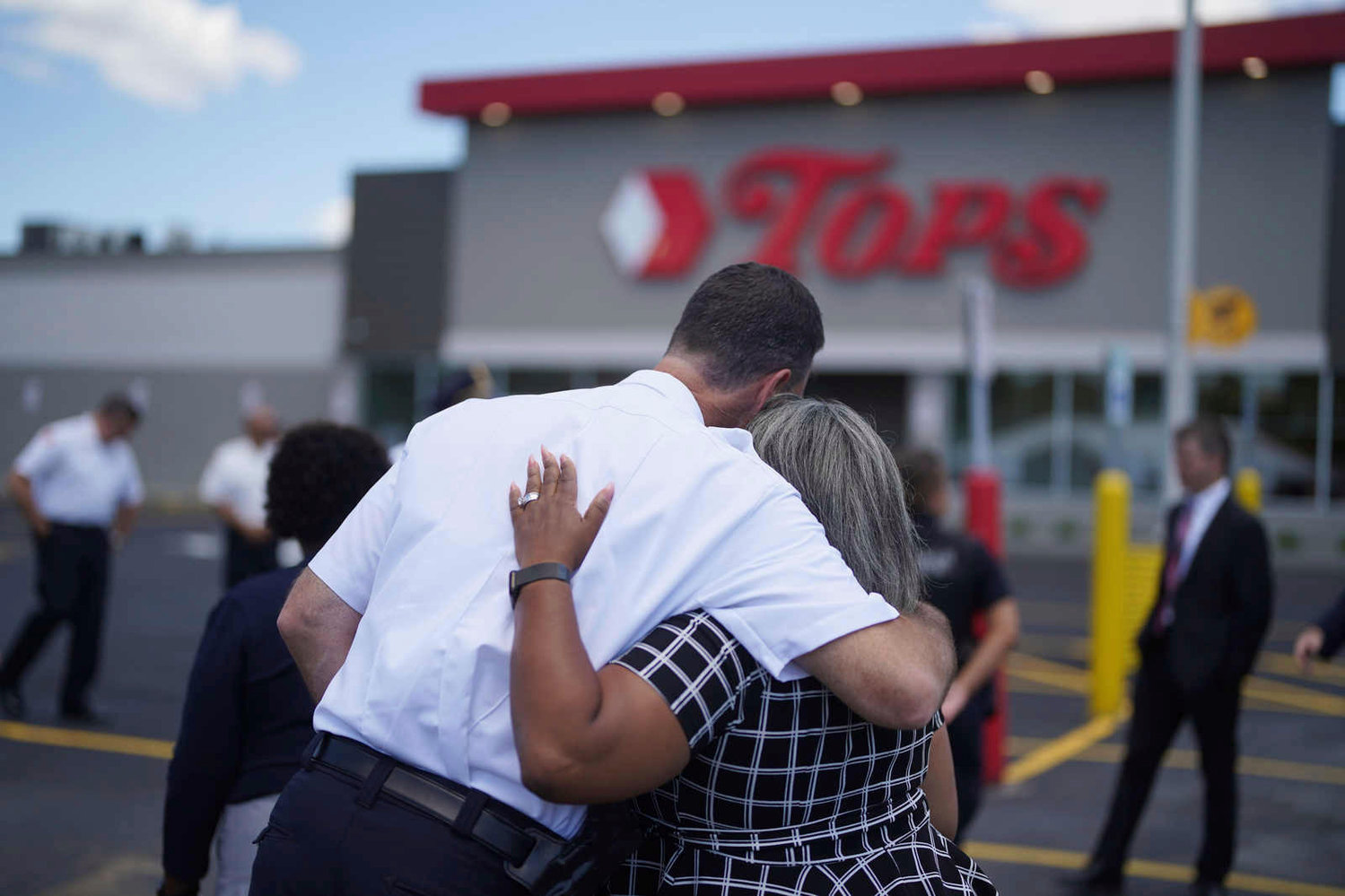 Buffalo Police Commissioner Joseph Gramaglia hugs Leah Holton-Pope, senior advisor to New York Assembly Majority Leader Peoples-Stokes prior to a ceremony to honor the victims on the two-month anniversary of the attack by a racist gunman at a memorial outside the store in Buffalo, N.Y., Thursday, July 14, 2022.