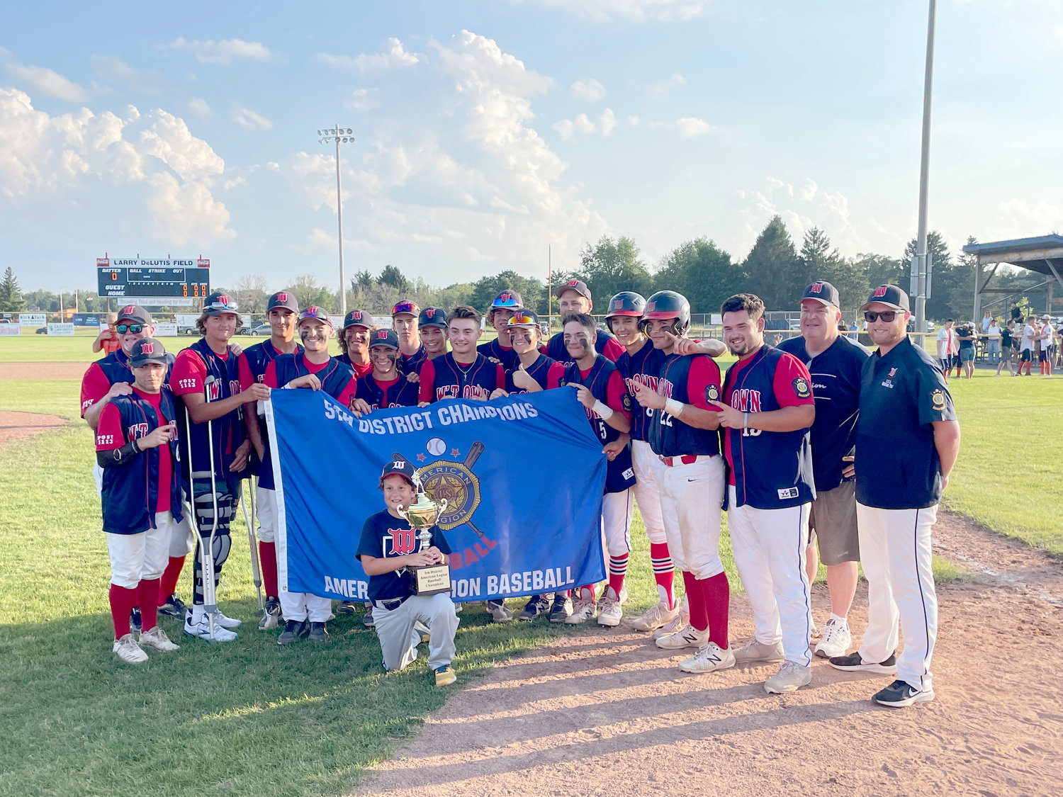 DISTRICT CHAMPS — The Whitestown Post American Legion baseball team holds up the District V championship banner it won Tuesday in a 1-0 win in eight innings over Smith Post of Rome at DeLutis Field in Rome. The team (20-2) will host District VI champion Harpursville (11-4) at 2 p.m. Saturday at DeLutis. The winner advances to the four-team state tournament that runs Tuesday through Thursday in Saugerties.