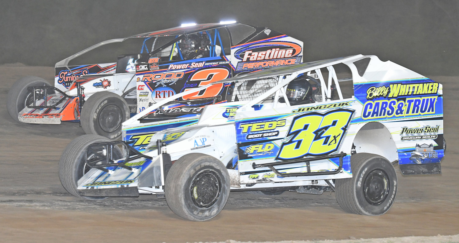 SIDE-BY-SIDE — Oneida's Matt Janczuk, No. 33x, races on the inside of Rome's Chris Mackey, No. 3, during the 30-lap feature race Thursday night at Utica-Rome Speedway. Janczuk went on to win the race and Mackey finished seventh.