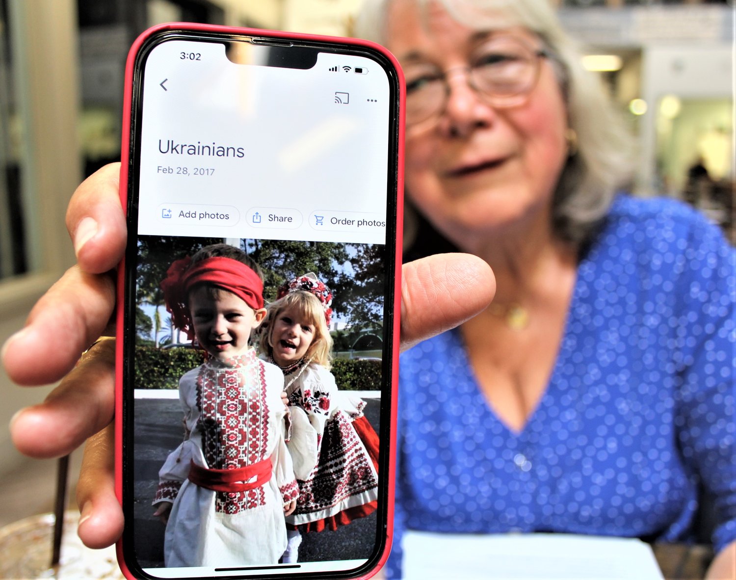 Cheri Sheridan shows off a picture of her grandkids in Ukrainian dress for a heritage day at their school. Sheridan was in the Marketplace Mall in Cortland on July 11.