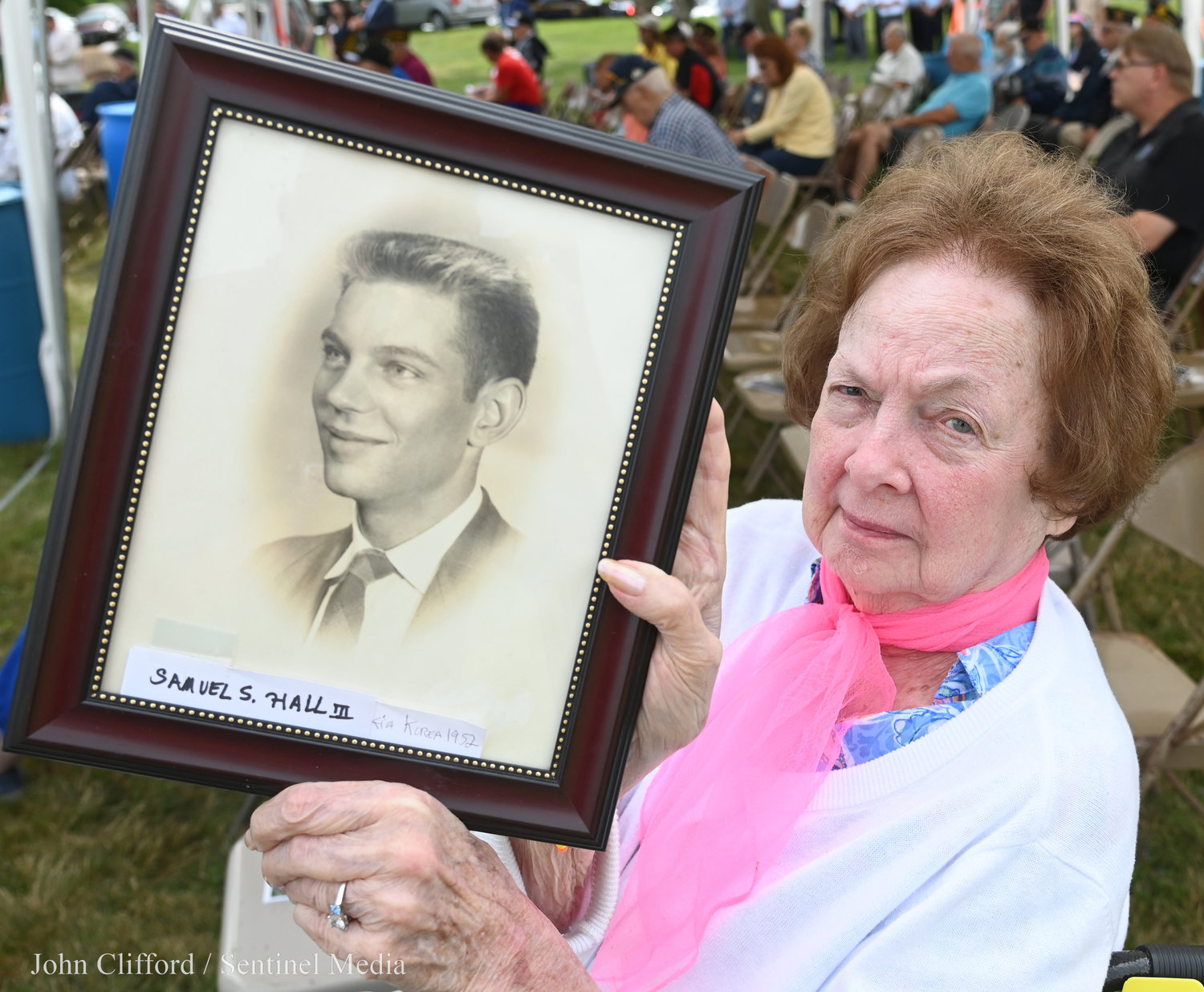 Ann Gambier holds up a framed photo of her first husband Samuel S. Hall III that was killed in action in 1952 in the Korean War.