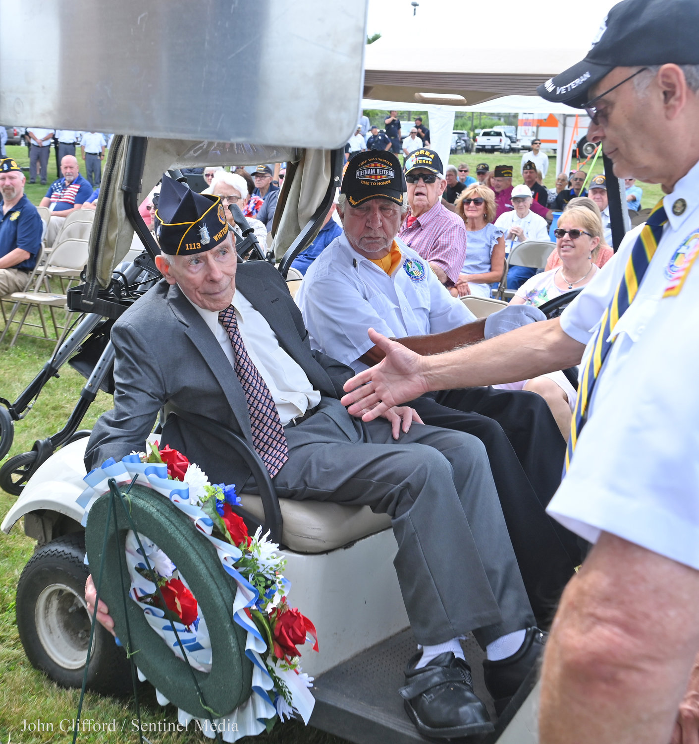 Thomas Buono - president of Vietnam Veterans of America 944 -goes to shake William Goodman's hand after the ceremonial wreath was placed at the new road marker.