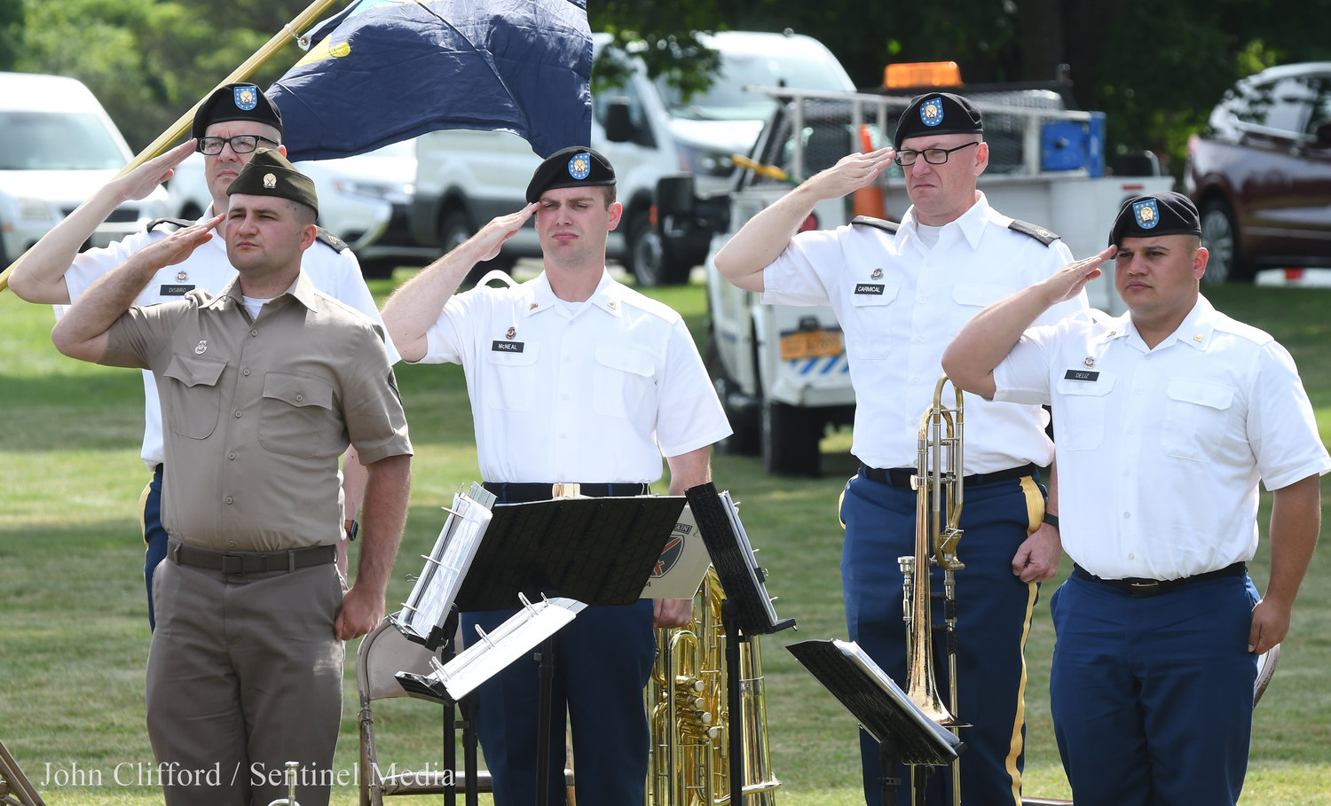 The 10th Mountain Division band members salute during the playing of the National Anthem.