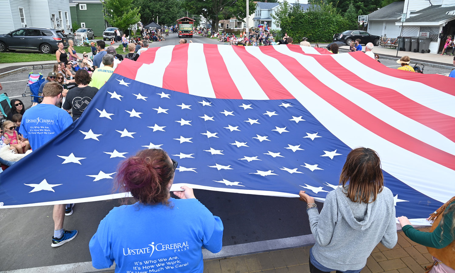 Members of the Rome Rotary Club carry Old Glory past crowds of spectators as the club members make their way along the Honor America Days parade route on Saturday, July 30.