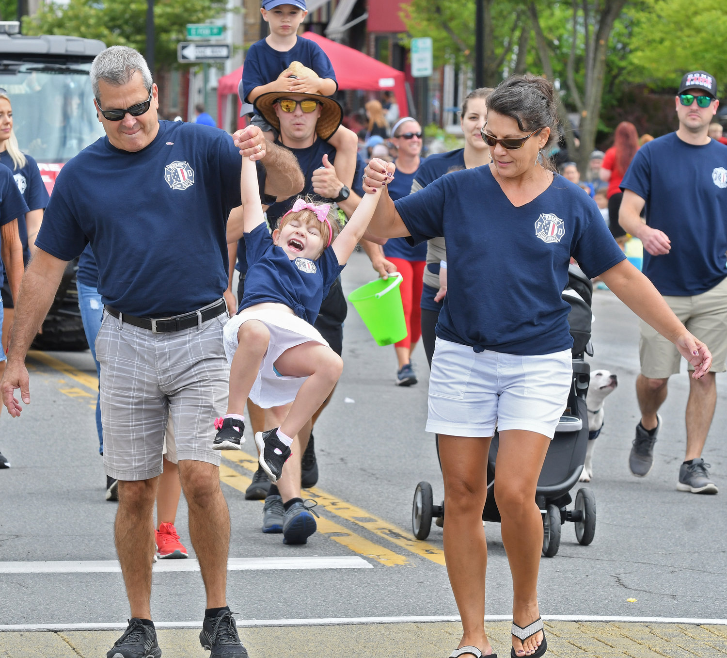 Members of the Rome Fire Department and their families show their community support as they roll out each roll for the Honor America Days festivities. Above, Chief Thomas Iacovissi, and his wife, Christine, watch as their granddaughter Audrey Iacovissi, 5, swings with glee.