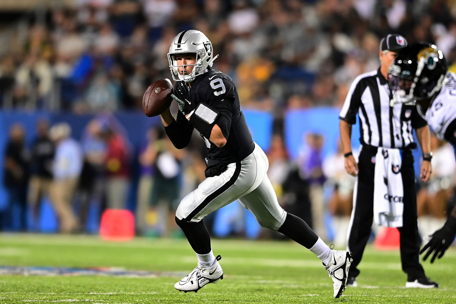 Las Vegas Raiders quarterback Nick Mullens rolls out looking to pass during the first half of the team's NFL football exhibition Hall of Fame Game against the Jacksonville Jaguars, Thursday, Aug. 4, 2022, in Canton, Ohio.