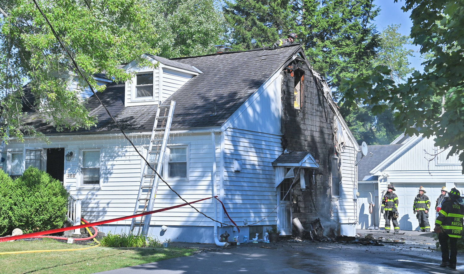 Utica firefighters survey the damage after an electrical issue on the outside of this home caused flames to burn up the side to the roof. A family of four have been displaced from their home on Buchanan Road on the city's north side, according to the Utica Fire Department.