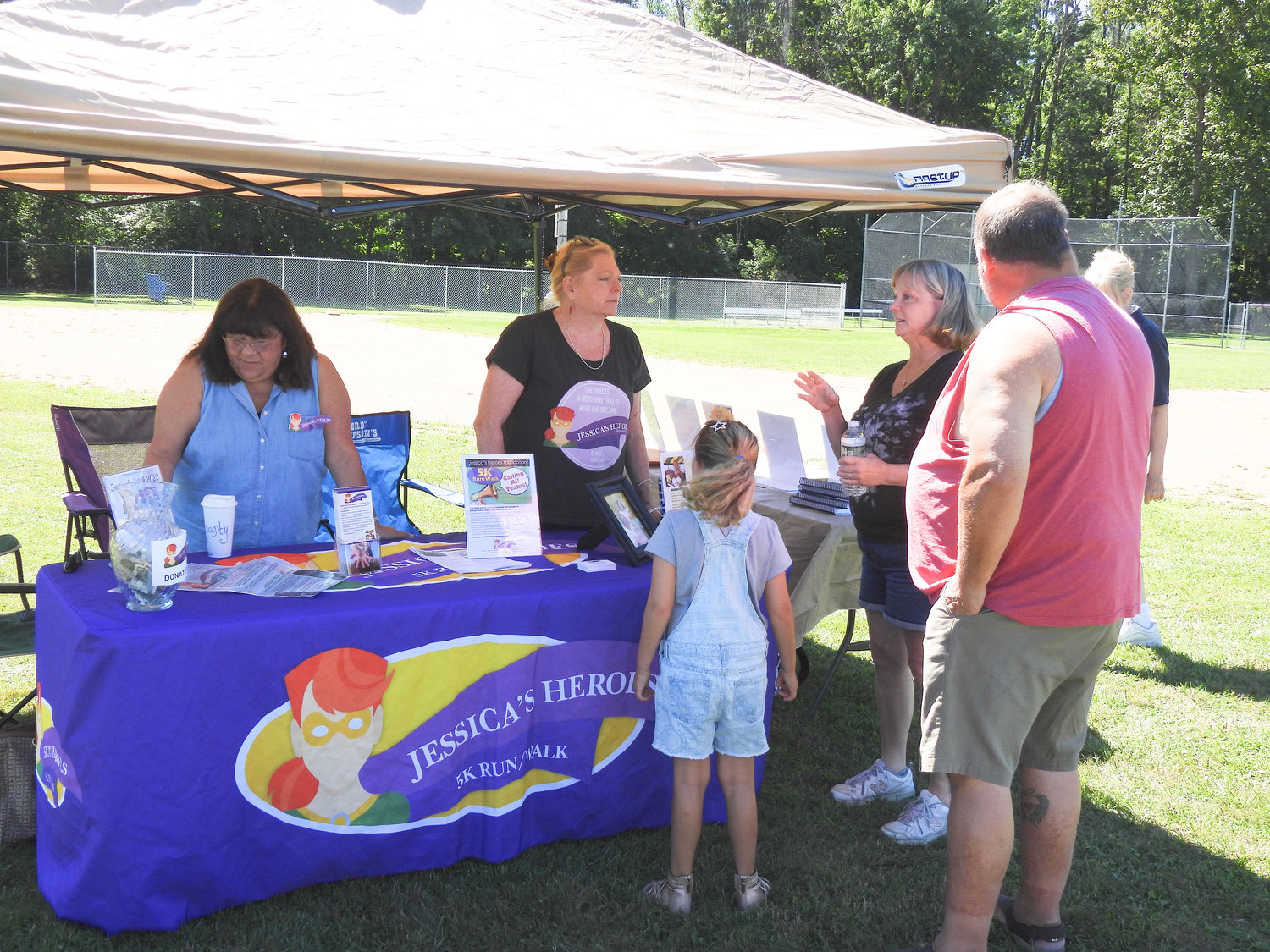 Members of Jessica's Heroes talks with local residents about their organization and how it helps local residents fighting cancer at Wanderers' Rest's 2022 Woofstock fundraiser on Saturday, Aug. 13.
