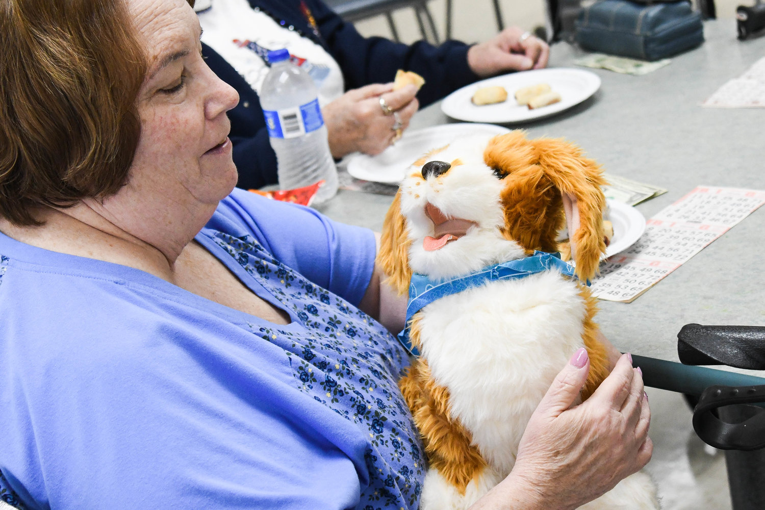 A member of the North Utica Senior Citizens Community Center holds an animatronic dog.