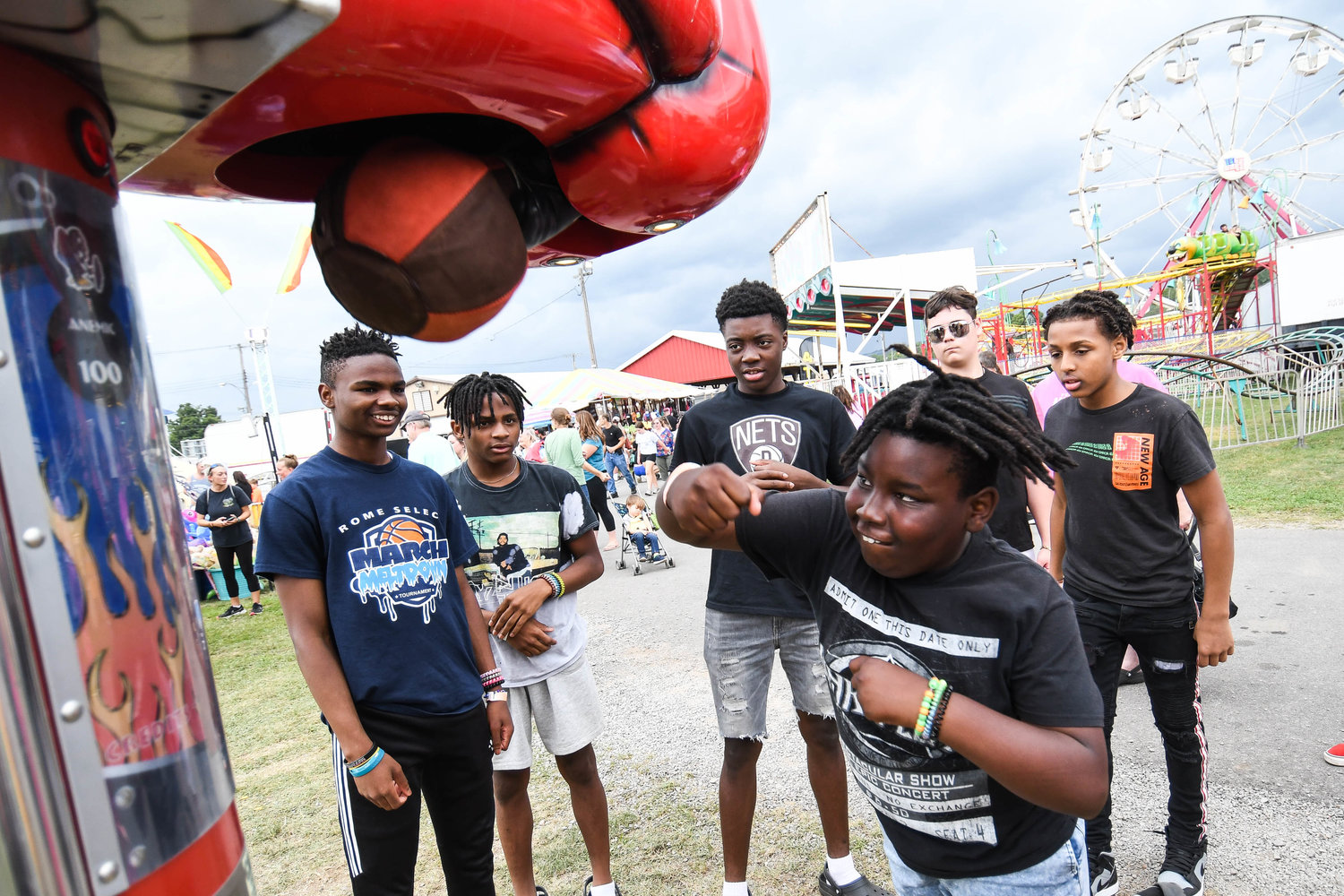 Fairgoers take turns hitting a boxing punch machine on Thursday at the Herkimer County Fair in Frankfort.