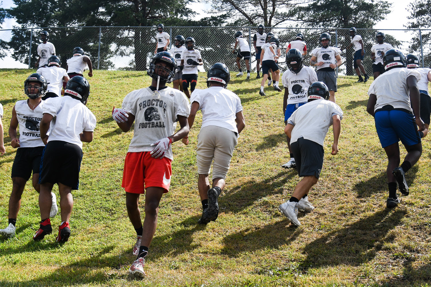 Thomas R. Proctor football players run sprints up and down a hill during practice on Monday D'Alessandro Stadium in Utica. The Raiders finished 4-4 as members of Class A last fall. The team is set open the season Friday, Sept. 9 at Christian Brothers Academy in Syracuse.