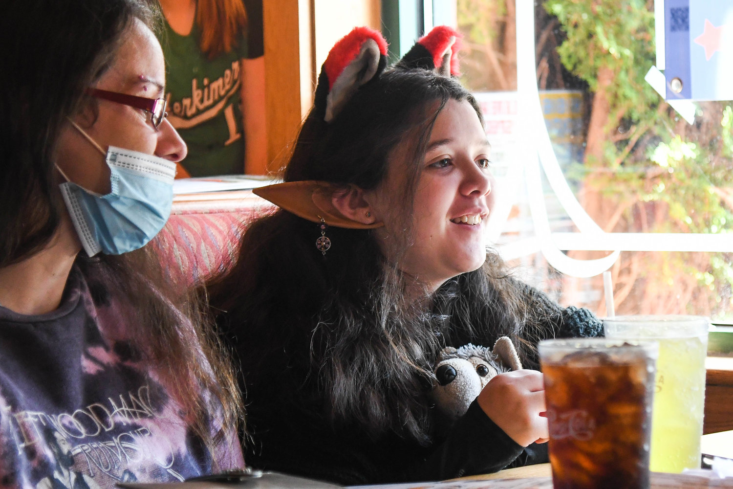 Twelve-year-old Serenity from Dolgeville holds a wolf stuffed animal and wears ears while receiving a wish from Make-A-Wish Central New York and Excellus BlueCross BlueShield on Wednesday at Applebee’s in Herkimer. Her favorite animals are wolves and her wish will allow her to go camping with them in a safe environment at a wolf conservation center in South Salem, Massachusetts.
