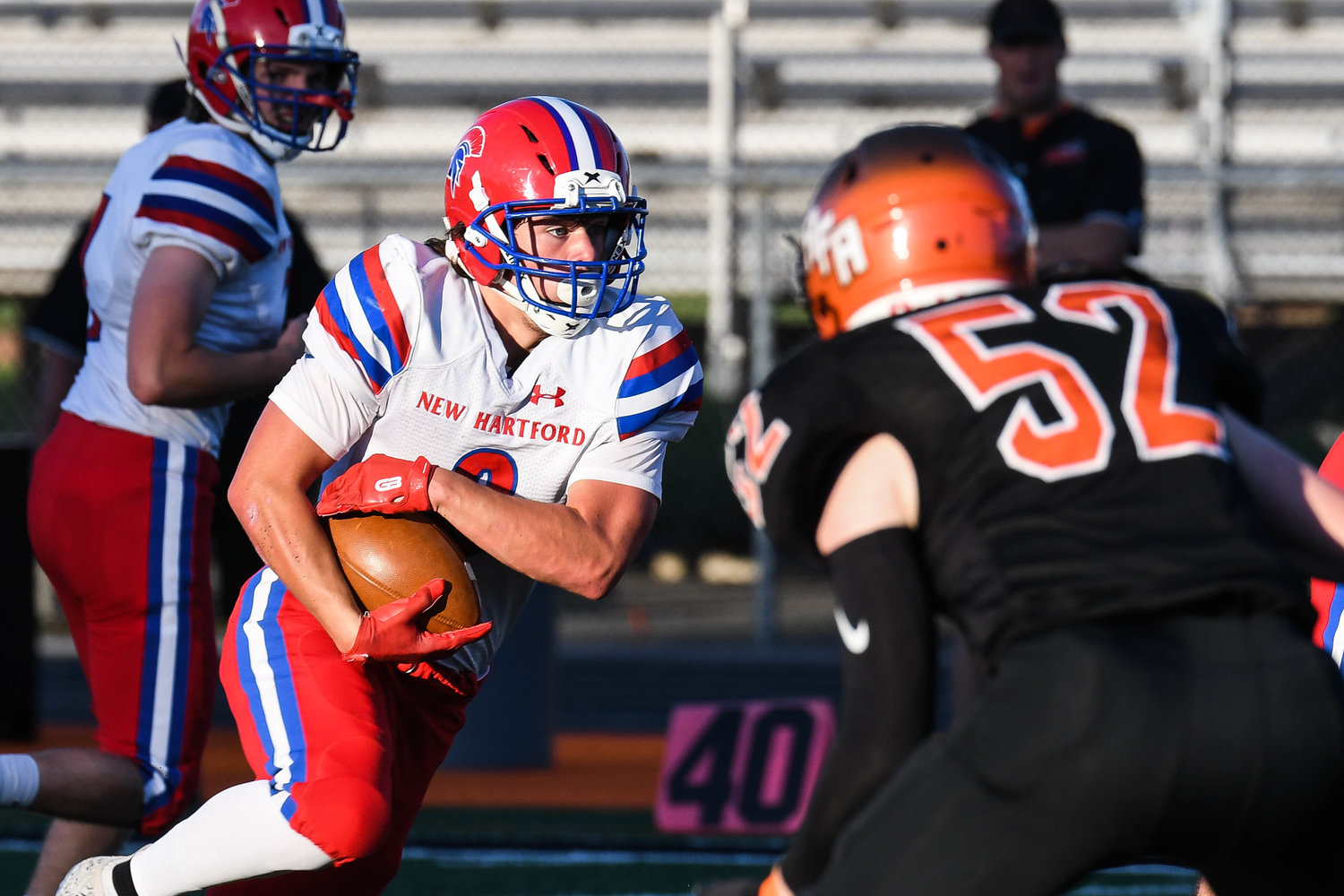 New Hartford running back Alex Collver runs during the game against Rome Free Academy on Friday at RFA Stadium. Collver ran 21 times for 127 yards and a score in the team's 52-26 win to open the season. Moving in for the tackle is RFA's Josiah Holmes.