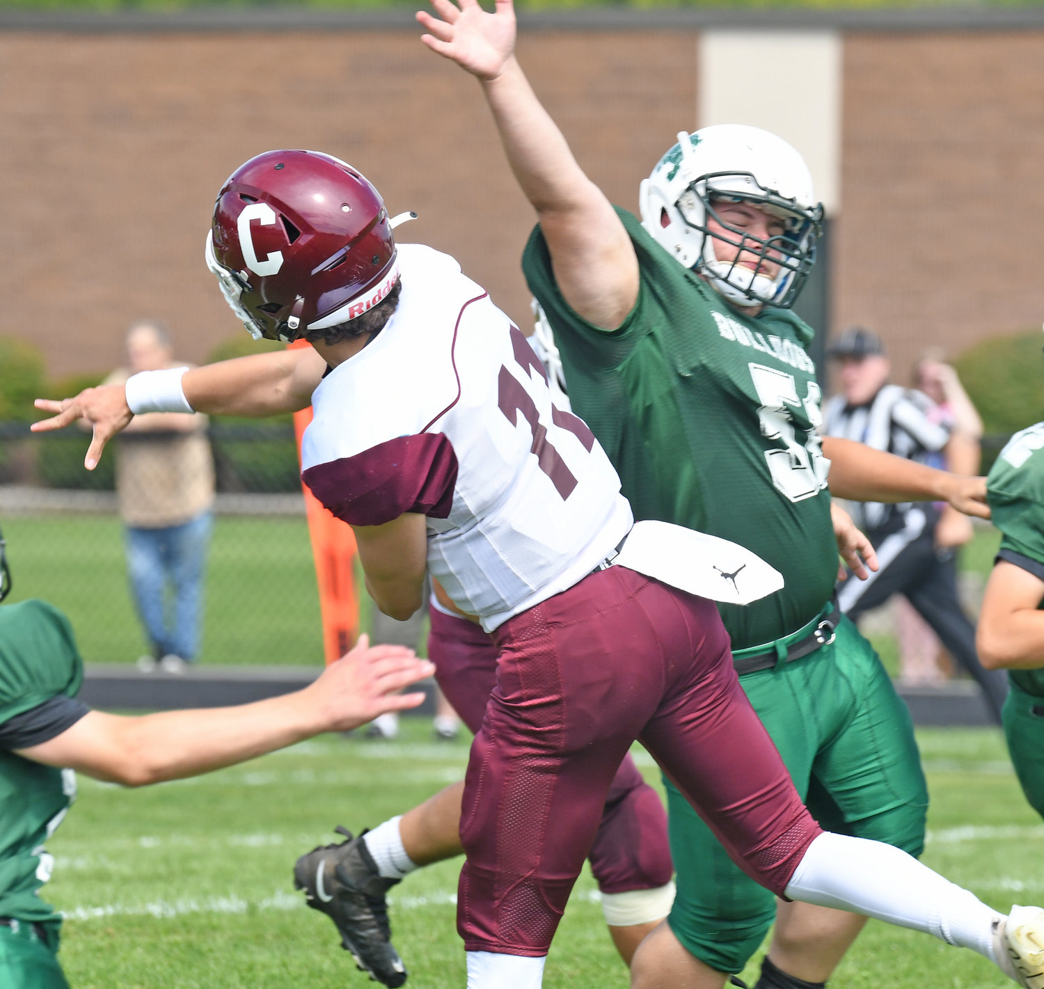 Clinton senior quarterback Ryan Chmielewski lets a touchdown pass fly with Westmoreland/Oriskany defensive lineman Aaron Wickham in his face in the first quarter of Saturday afternoon's non-league game in Westmoreland. The Warriors won 28-6.