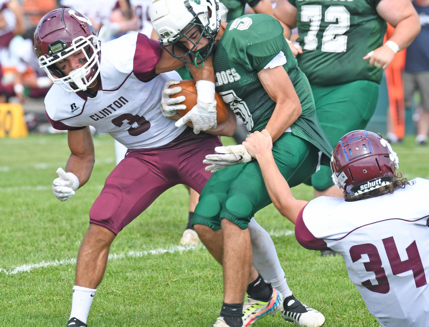 As Clinton's Benjamin Pelkey tries to drag down Westmoreland/Oriskany's Cameron Rautenstrauch, teammate Cameron Maline tries to strip the ball from his hand during Saturday afternoon's non-league game in Westmoreland. The Warriors won 28-6.