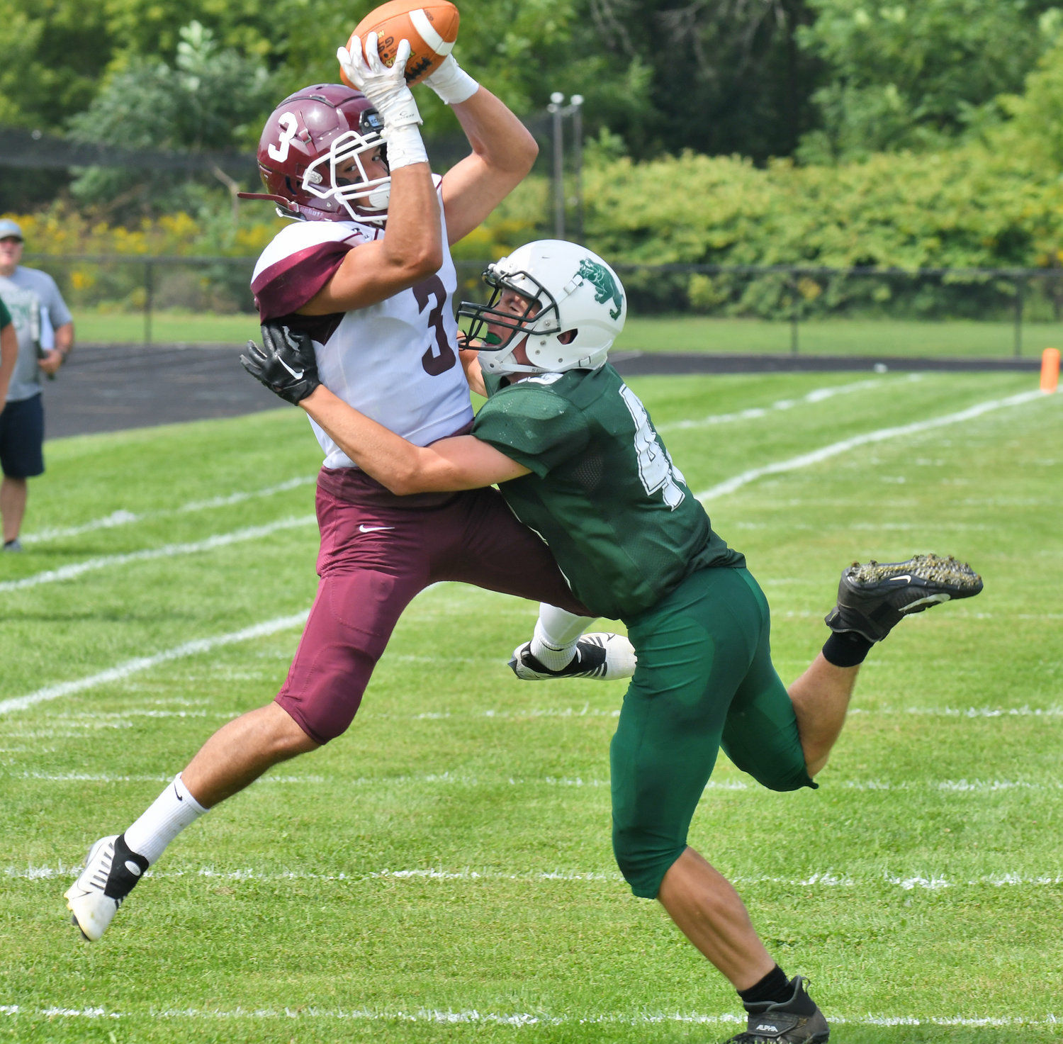 Clinton's Cameron Maline catches the ball with Westmoreland/Oriskany's Jack Williams defending in the first half during Saturday afternoon's non-league game in Westmoreland. The Warriors won 28-6.