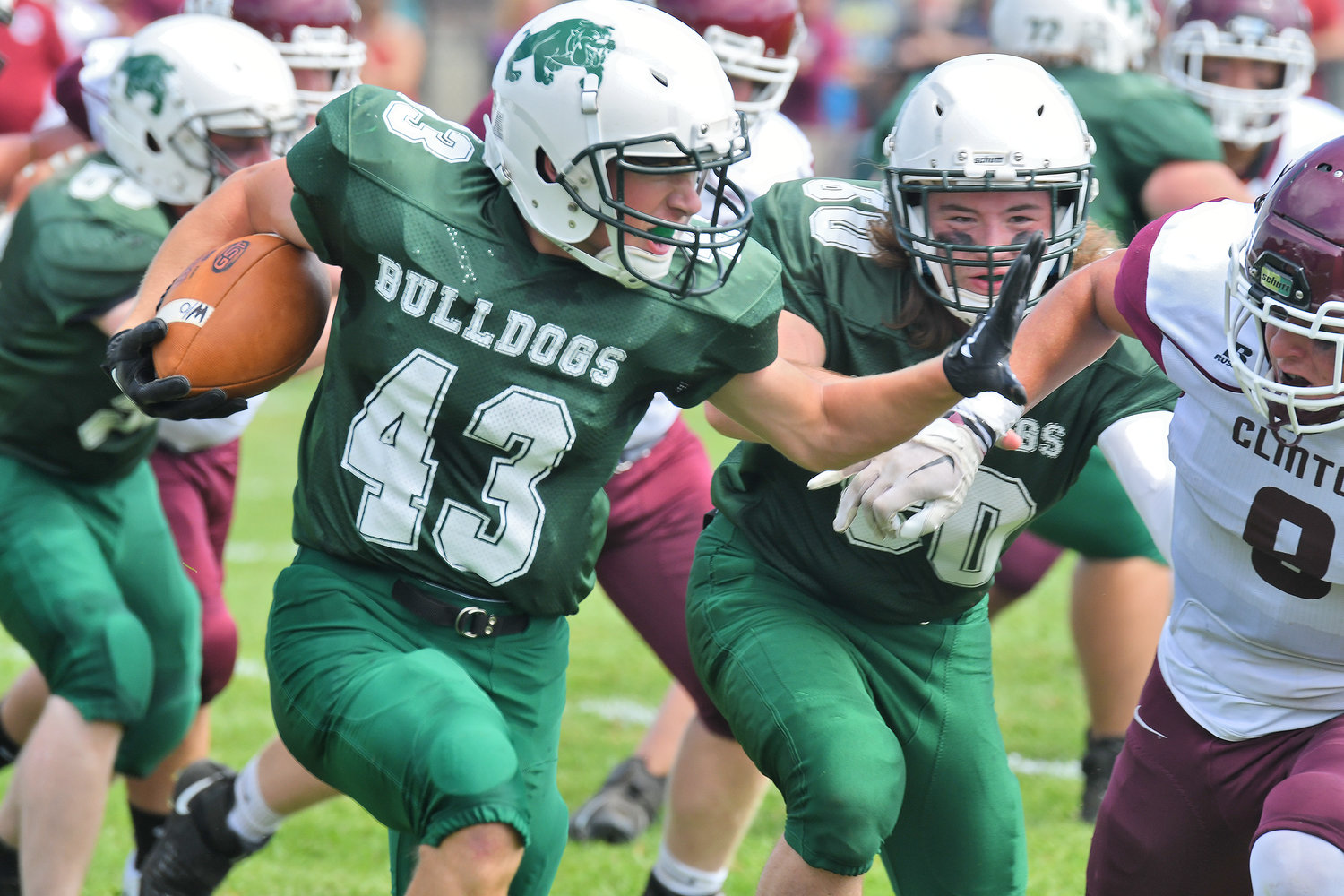 Westmoreland's Jack Williams puts his arm out to fend off Clinton's Caden Hinderling during Saturday afternoon's non-league game in Westmoreland. The Warriors won 28-6.