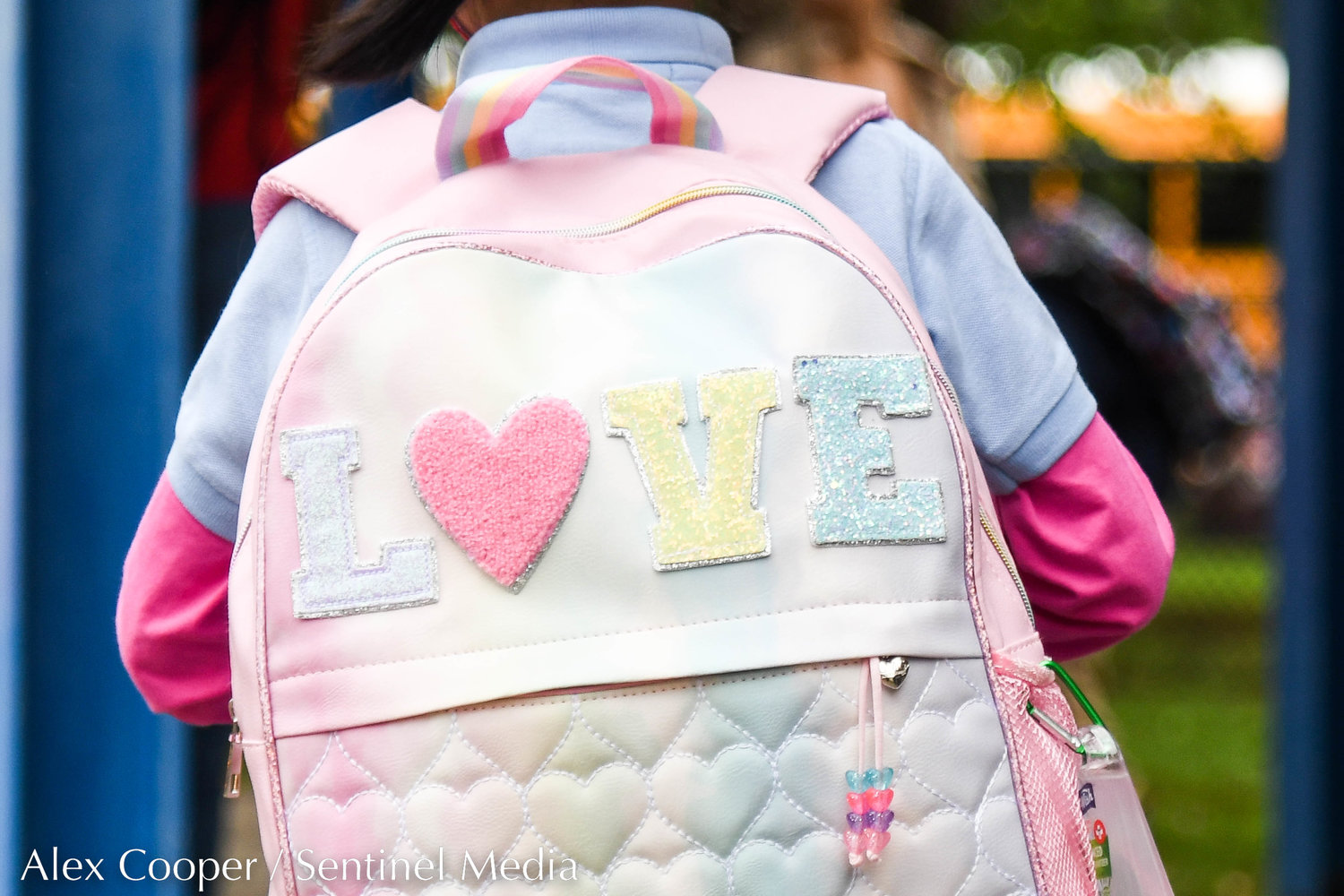 A student sports a "LOVE" backpack outside of Utica Academy of Science Elementary School during the first day back to school on Tuesday in Frankfort.