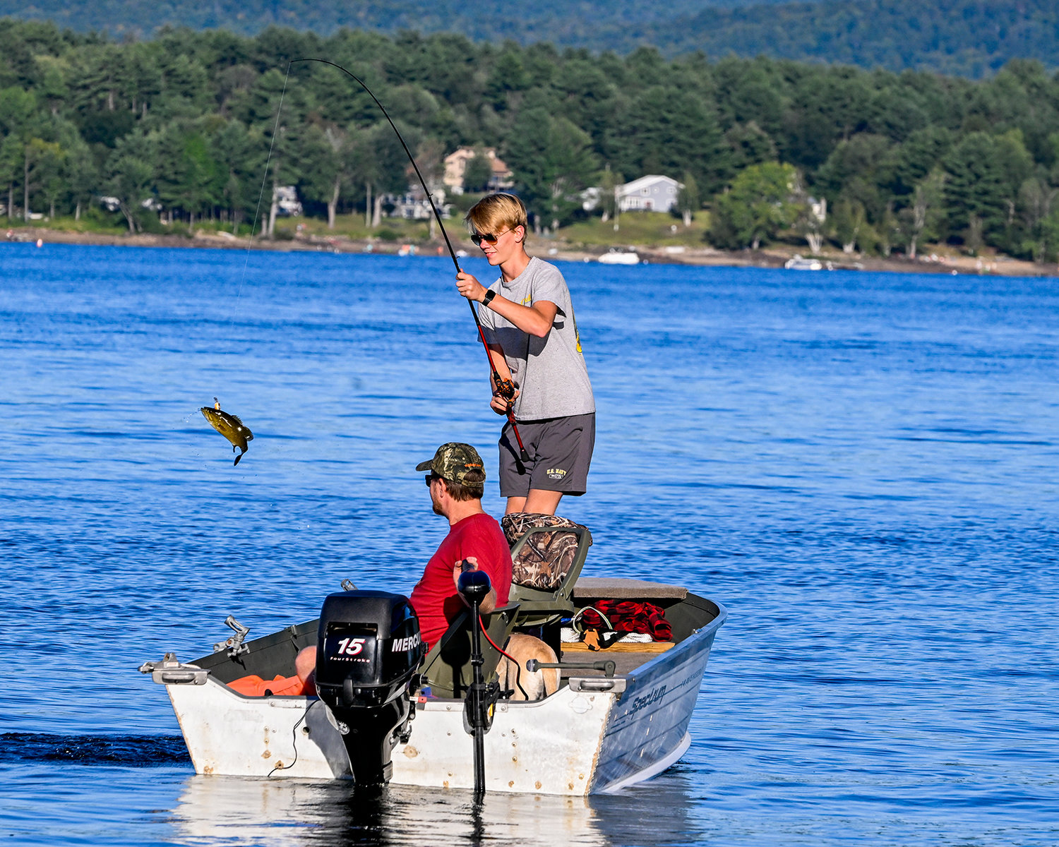 Jack Wasiakowski, 14, reels in a small mouth bass with his father Cory on Sacandaga Lake near Thompson’s Marina in Northampton on Friday, Sept. 2.